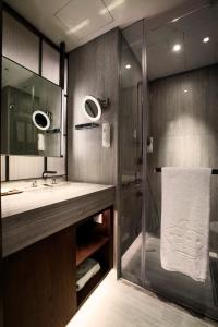 香港英皇骏景酒店的带淋浴、盥洗盆和镜子的浴室
