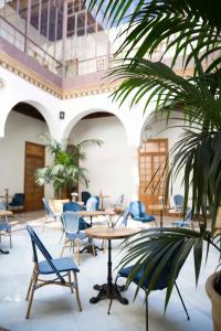 塞维利亚Santiago 15 Casa Palacio的一间设有桌椅的房间和棕榈树