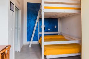 里米尼维京酒店的一间卧室配有一张带黄床单的双层床