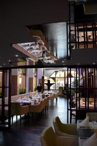 莫雄马扎尔古堡米纳瓦酒店 的一间设有桌椅的餐厅,以及一位背景人士