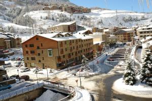 卡尼略Apartamentos Turísticos Roc Del Castell的雪中的一个小镇,背景是山