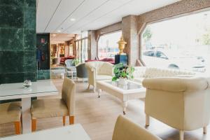 阿尔么丽亚伊姆巴加多酒店的一个带桌椅的沙龙和窗户
