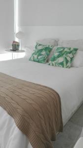 卡列罗港Apartamento Calero的一张白色的床,上面有一条毯子