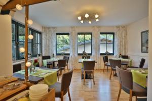 OberahrLandhotel Villa Moritz garni的餐厅设有桌椅和窗户。