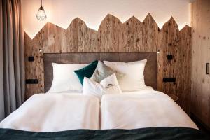 特伦托Chalet Schmied的一间卧室配有两张带白色床单和枕头的床。