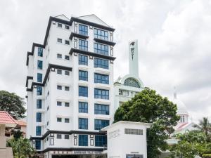 新加坡Harbour Ville Hotel的一座高大的白色建筑,有钟楼