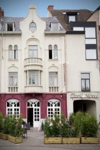 鲁瑟拉勒Parkhotel Roeselare的一座白色的大建筑,有粉红色的酒店