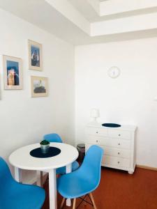 格丁尼亚Hostel Marina的一间设有白色桌子和蓝色椅子的客房