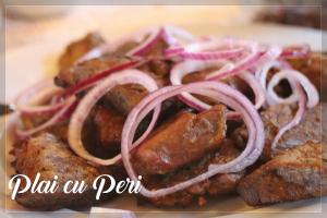 瑟彭察"Plai cu Peri"的盘子里放着肉和洋葱的食物