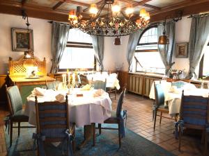 巴登-巴登Landhotel Traube的一间带桌椅和吊灯的用餐室