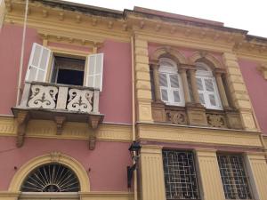 卡洛福泰Casa Tonina的粉红色的建筑设有阳台和窗户