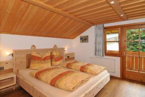 施万高Haus am Kienberg的一间带两张床的卧室,位于木天花板的房间