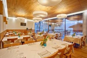 StoroAgritur La Polentera的餐厅设有白色的桌椅和大窗户