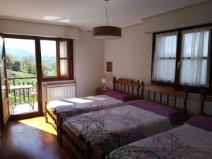 阿斯蒂加拉加卡萨乡间阿托拉公寓的一间卧室设有三张床和一个美景窗户。