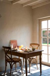 达默霍夫德斯丁诺文住宿加早餐酒店的桌子和两把椅子,位于带桌子和窗户的房间