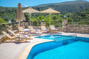 圣特里亚斯Villa Tinadora的游泳池旁设有椅子和遮阳伞