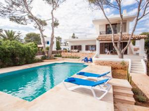 卡拉菲格拉Villa Estrella Sea View的一座带游泳池和两把躺椅的房子
