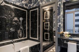 马德里Relais & Châteaux Heritage Hotel的带浴缸和盥洗盆的浴室