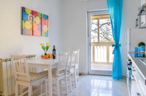 乌马格Apartment Family Time的厨房配有白色的桌椅和冰箱。