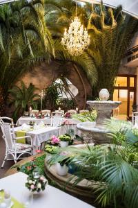 科希策金色皇家精品酒店 & 温泉中心的一间带桌子、喷泉和吊灯的餐厅