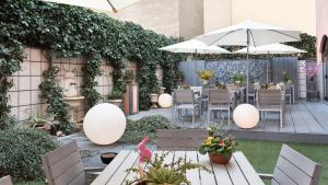米兰伦巴蒂雅酒店的一个带桌椅和遮阳伞的庭院