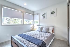 西雅图Central Modern Home with Rooftop的一间卧室设有一张床和两个窗户。