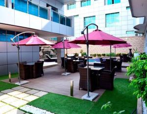 楠普拉Seasons hotel and spa的一个带桌椅和粉红色遮阳伞的庭院。
