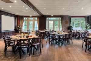 恩斯赫德Fletcher Hotel-Restaurant De Broeierd-Enschede的用餐室配有木桌和椅子