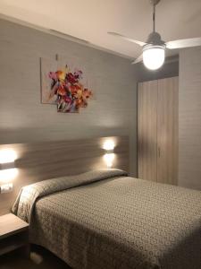 西尔米奥奈费奥达里索酒店的卧室配有一张床,墙上挂有绘画作品