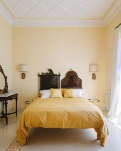 锡拉库扎阿基米德旅馆的一间卧室配有一张带黄色床单的大床