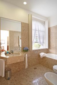 英雄港金塔达斯梅塞旅馆的带浴缸、水槽和镜子的浴室