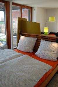 马尔肖"An der Wasserstraße"的一间卧室设有两张床、床头板和窗户。