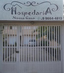 Braço do NorteHospedaria Nossa Casa的建筑前的大门,有标志