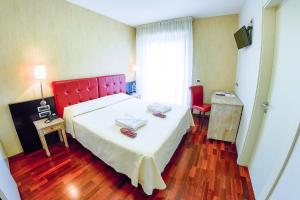 佩斯卡拉维多利亚酒店的一间卧室配有一张大床和红色床头板