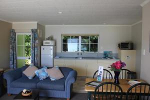 Kenepuru Sounds特玛希亚湾度假酒店的一间带2张蓝色沙发的客厅和一间厨房