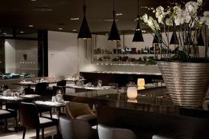 斯图加特斯图加特机场展览中心温德姆酒店的一间带桌椅和花瓶的餐厅