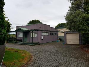陶波Central Taupo Townhouse的车道上带车库的紫色房子