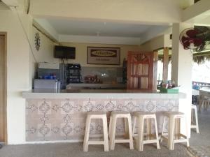 BarasJoSurfInn, Puraran Beach的厨房前设有带凳子的酒吧