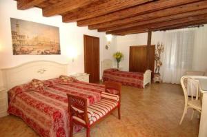 威尼斯Ca' Dei Leoni的一间卧室配有两张床和一张桌子及椅子