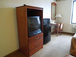 布鲁克林布鲁克林红地毯酒店的一间大型木制娱乐中心,里面配有电视,位于酒店客房内