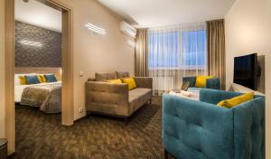 维尔纽斯泽梅特斯酒店的酒店客房配有床、沙发和镜子