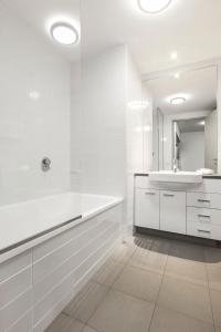 悉尼悉尼奥林匹克公园凯斯特公寓式酒店的白色的浴室设有水槽和镜子