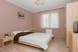 斯维诺乌伊希切Apartamenty Villa Park by Renters的一间卧室设有一张大床和一个窗户。