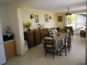 滨海卡瓦莱尔La Bastide Fleurie的厨房以及带桌椅的用餐室。