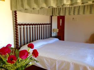 阿尔库迪亚Sant Jaume的一间卧室,床上有红色的鲜花