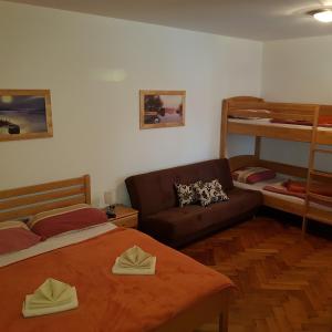 拉什科卡特尔旅馆的一间卧室配有一张床、一张沙发和双层床。
