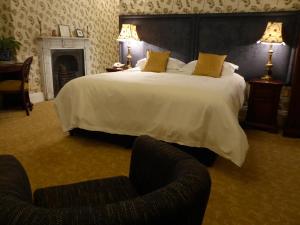 巴森斯韦特水上会馆酒店的一间卧室配有一张大床和两把椅子