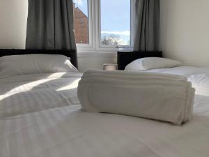 格伦罗西斯Glenrothes Central Apartments - One bedroom Apartment的一间卧室设有两张带白色床单的床和窗户。