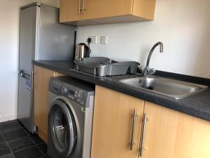 格伦罗西斯Glenrothes Central Apartments - One bedroom Apartment的厨房配有水槽和洗衣机