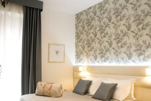 贝拉里亚-伊贾马里纳拉康格里雅酒店的一间卧室配有一张带花卉壁纸的床